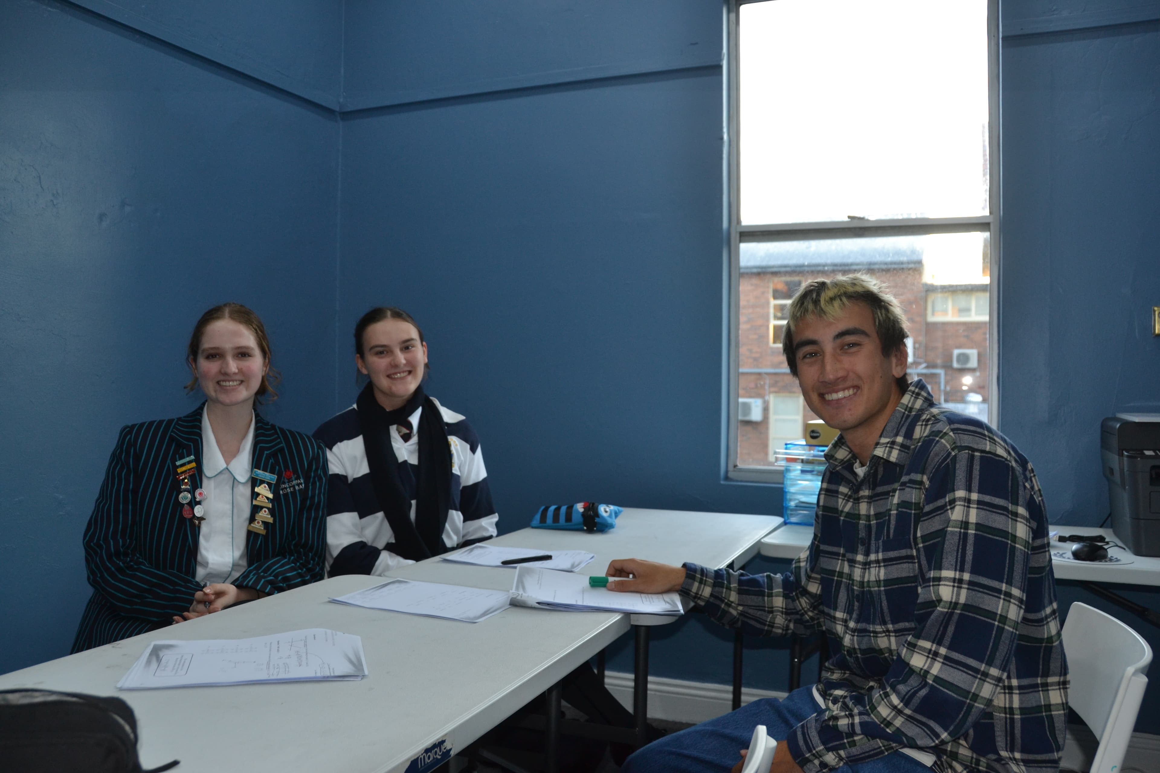 A First Education student and tutor at a centre desk, celebrating the student's election as school captain.