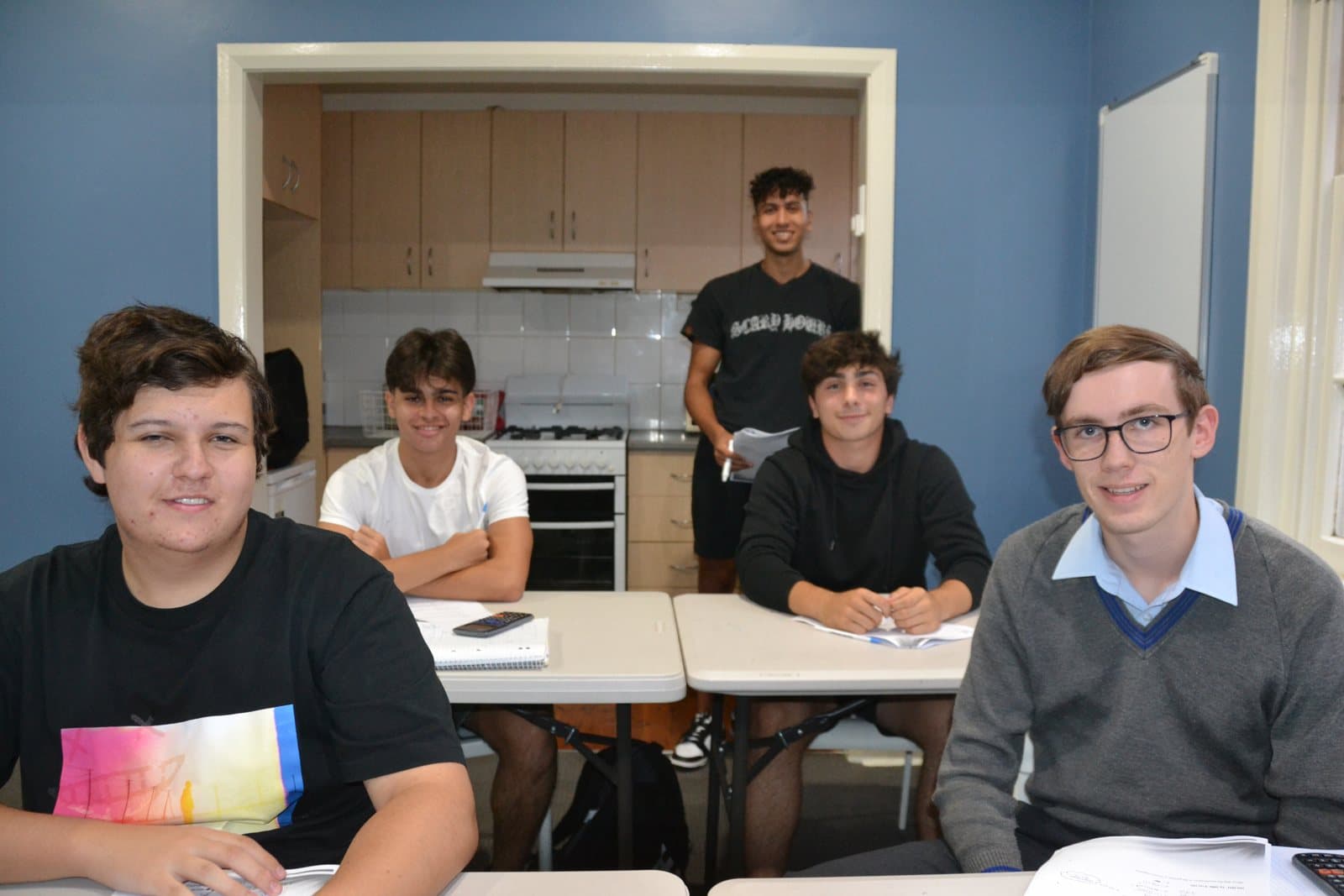 Tutors and HSC students with past papers at a First Education centre