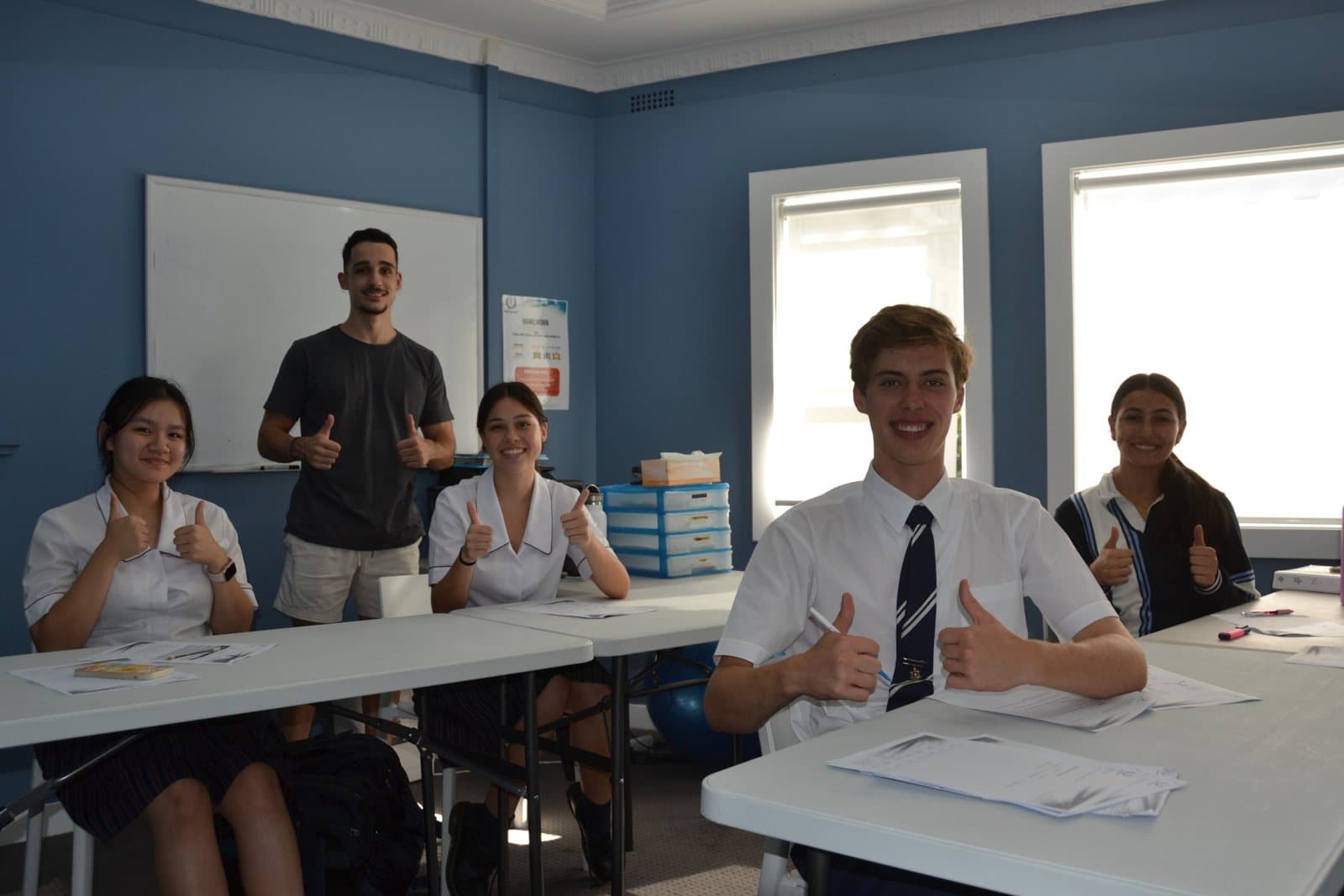 Tutors and HSC students with past papers at a First Education centre