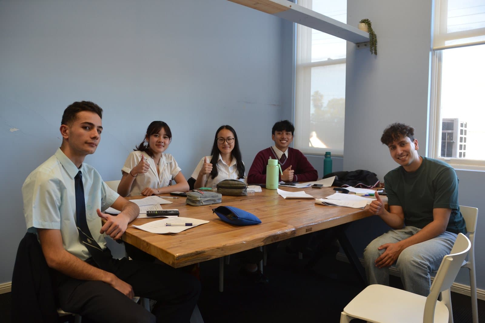 Tutors and HSC students with past papers at a First Education centre